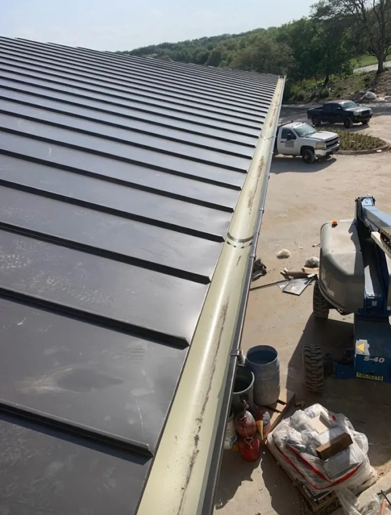 Standing seam panel and gutter detail on a metal roofing jobsite in Sugar Hill